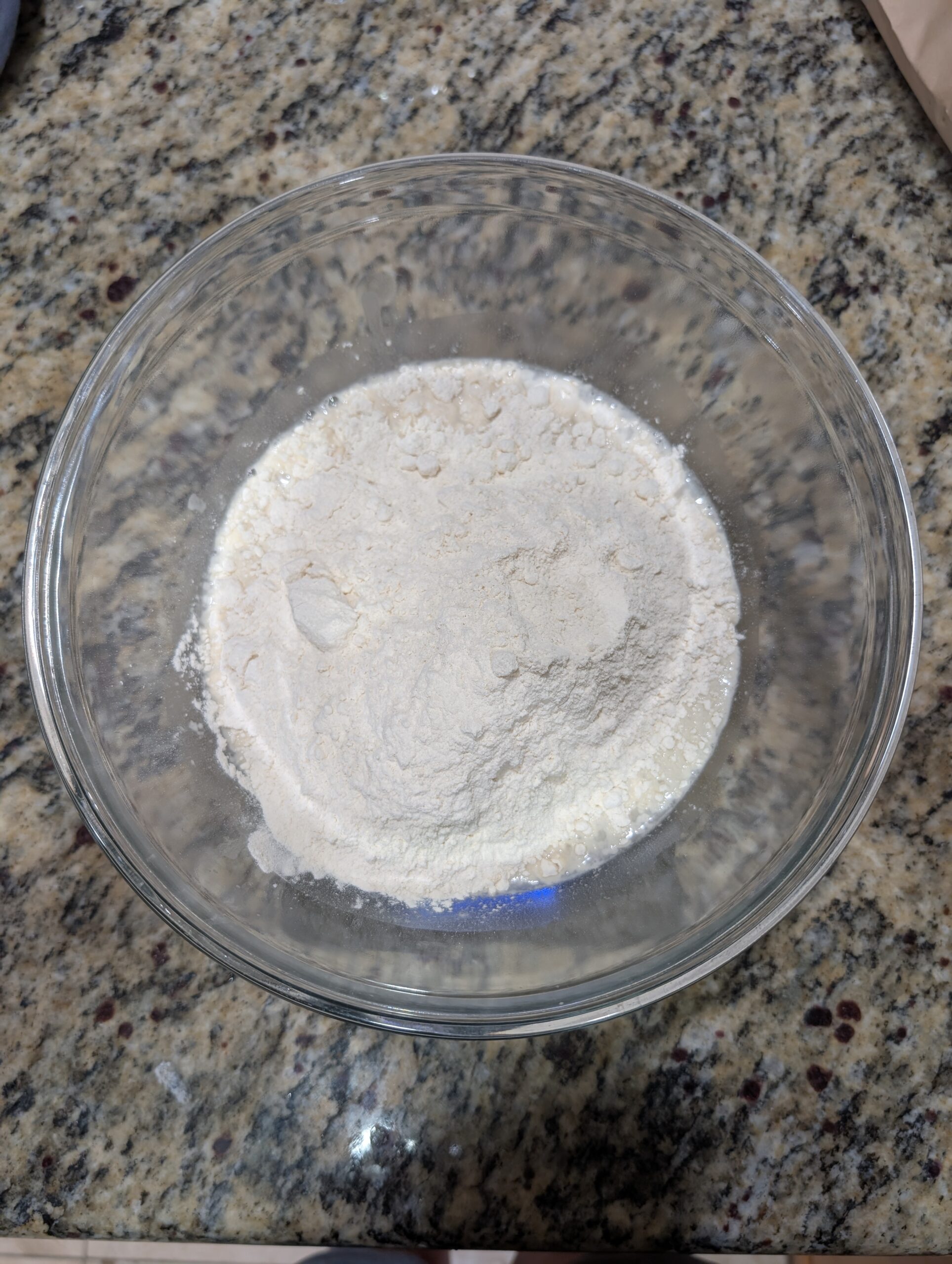 Bread flour measured in a clear glass mixing bowl for homemade sourdough bread recipe
